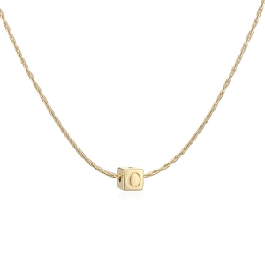 Détail d'un pendentif cube plaqué or 18 carats poli avec une lettre O gravée sur la face