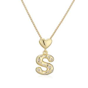Dettaglio macro della collana con lettera S dorata e zirconi con gancio a forma di cuore