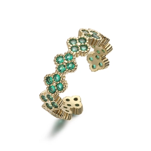Detailed close-up of 18K gold-plated clover ring with emerald green crystal stones