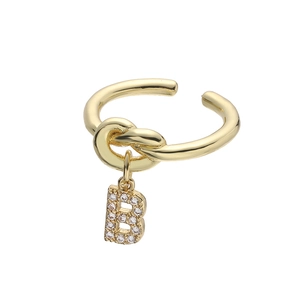 Detail van gouden knoopring met een met kristallen ingelegde hanger met de letter B