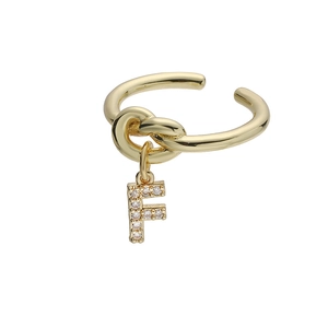 Detailopname van gouden knoopring met een glanzende hanger van de letter F en zirkoon