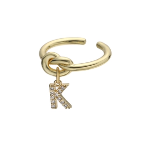 Detailopname van de gouden letter K-ring met zirkonia steentjes en een knoopontwerp