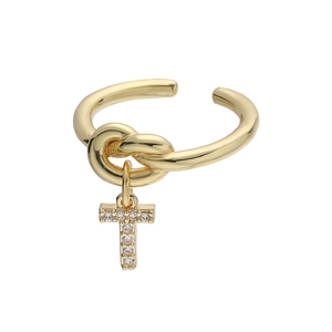 Detail van gouden knoopring met een kristal-geplaveide letter T-hanger en zirkooninlays