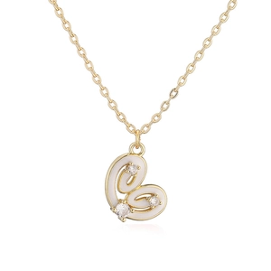 Detailaufnahme der Herzkette mit weißem Emaille-Inlay und drei Zirkonia-Steinen im Gold-Look