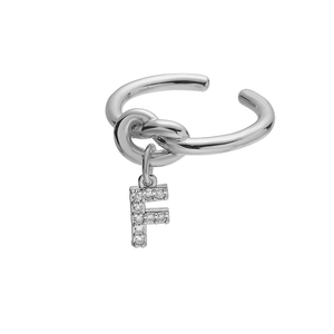Detailopname van een zilverkleurige knoopring met een met zirkonia ingelegde letter F-hanger