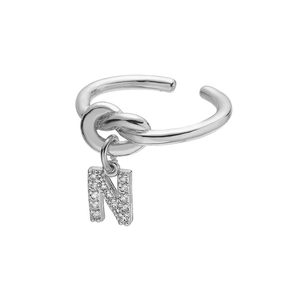 Macro detail van zilveren knoopring met bungelende letter N hanger en zirkonia-inleg
