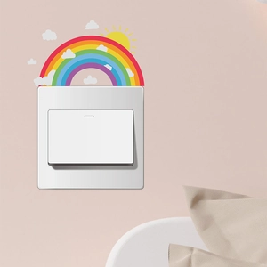 Luminous rainbow wall stickers with sun and clouds applied above a light switch plate