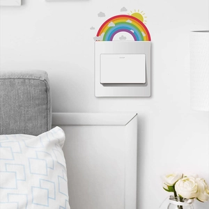 Close-up of rainbow and sun luminous wall sticker applied above a light switch