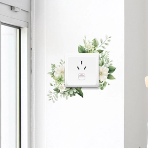 Gros plan d'un sticker mural floral avec feuilles vertes sur interrupteur blanc