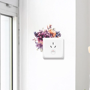 Détail de stickers muraux floraux avec dahlias violets et fleurs orange autour d'une prise