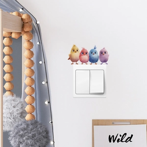 Close-up of four colorful cartoon bird wall stickers applied above a light switch