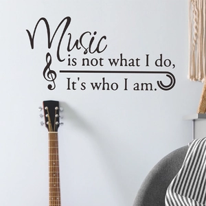Music themed black wall sticker with quote on a white background near a guitar neck