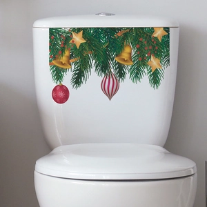 Christmas tree bells and star stickers on a white toilet tank for festive home decoration