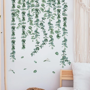 Close-up detail of green eucalyptus vine wall stickers with dragonflies in a cozy bedroom