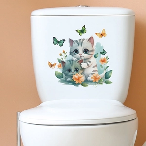 Close-up of cute cartoon cats and butterflies self-adhesive decals on a white toilet tank