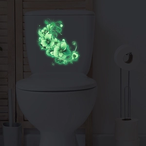 Luminous floral wall stickers showing green fluorescent flower patterns on a toilet tank