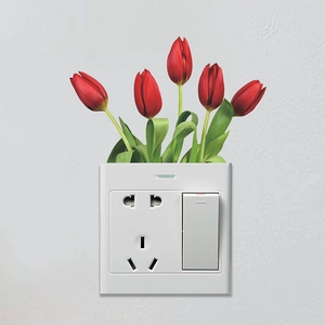 Close-up of red tulip wall sticker decorating a white light switch and power socket