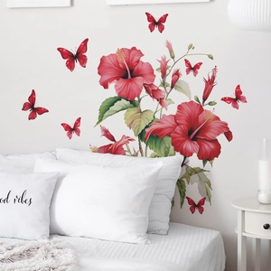 Detail view of red hibiscus and butterfly wall stickers on a clean white bedroom wall
