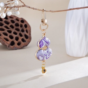 Detail of purple brocade gourd pendant with gold buckle hanging on a natural branch