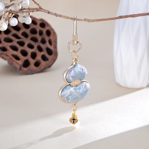 Detailed view of handmade light blue silk gourd charm on a natural branch