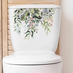 Detail of tropical green leaf and flower wall sticker on white toilet tank