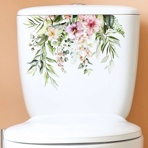 Detailed view of watercolor tropical floral decals on a white bathroom toilet tank