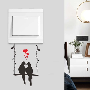 Decorative wall sticker featuring two birds on a swing with red hearts for light switches