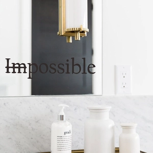 Minimalist 'Impossible' wall decal in matte black finish on modern bathroom mirror