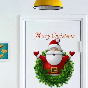 Festive Merry Christmas wall sticker with Santa Claus and green wreath on a white door