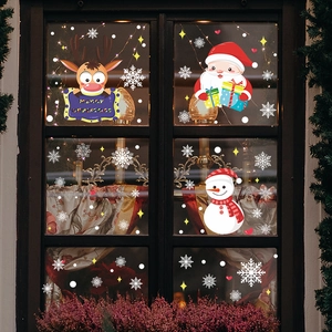 Détail de stickers de Noël avec renne et Père Noël sur une fenêtre en verre décorée