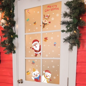 Christmas window decals with Santa Claus and reindeer on a glass door with festive wreath