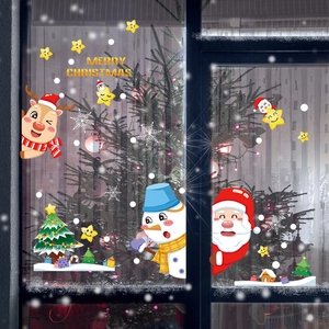 Détail de stickers de Noël avec Père Noël et rennes sur vitrine en verre