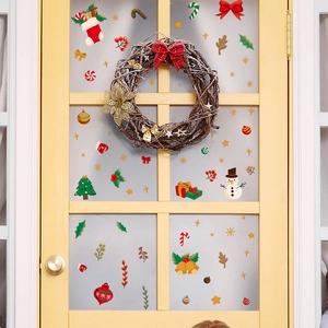 Détail de stickers de Noël avec bonhommes de neige et sapins sur porte vitrée