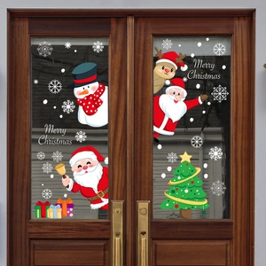 Christmas window decals with Santa, snowman and tree on a brown double glass door