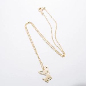 Detail of gold puppy pendant with hollowed-out eyes on a fine link chain necklace