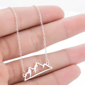 Detail of a silver mountain peak pendant with minimalist hollow cut-out design