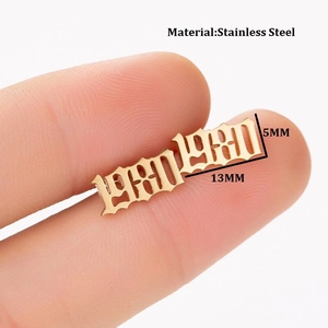 Macro detail of gothic style year 1980 gold stud earring in polished stainless steel