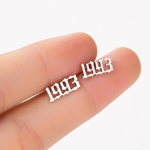 Macro detail of custom 1993 year stud earring in silver gothic font stainless steel