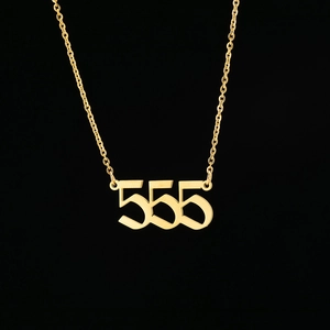 Macro shot of gold stainless steel gothic 555 angel number pendant on a link chain