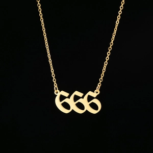 Macro shot of gold stainless steel 666 angel number pendant with a fine cross chain