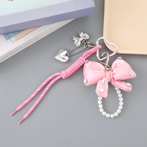 Pink ribbon bow charm with pearls and rhinestones on braided strap for handbags