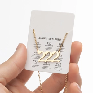 Macro shot of 222 angel number pendant in gold finish on an explanation card