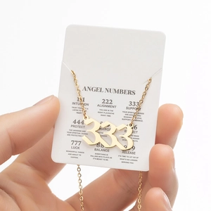 Golden 333 angel number pendant on a card with meanings of numerical sequences