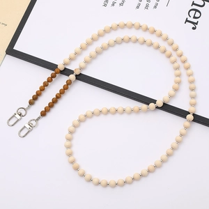 Detail of beaded crossbody strap with natural wood beads and silver lobster clasps