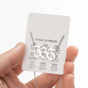 Detail of silver angel number 555 necklace pendant on display card with O-chain link