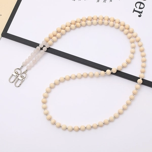 Detail of beaded crossbody strap with cream wood beads, pink stones and silver swivel clasps