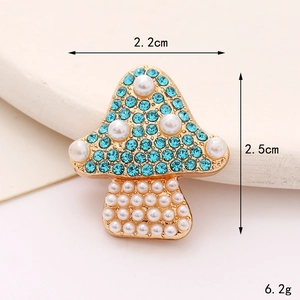 Detailed view of mushroom-shaped brooch with blue rhinestones and white pearls