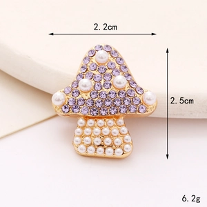 Detailed macro view of a mushroom-shaped charm with purple rhinestones and white pearls