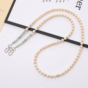 Detail of wooden beads and green natural stone strap with silver metal lobster clasps
