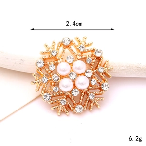 Detail showing a 2.4cm gold snowflake charm with white pearls and sparkling zircons